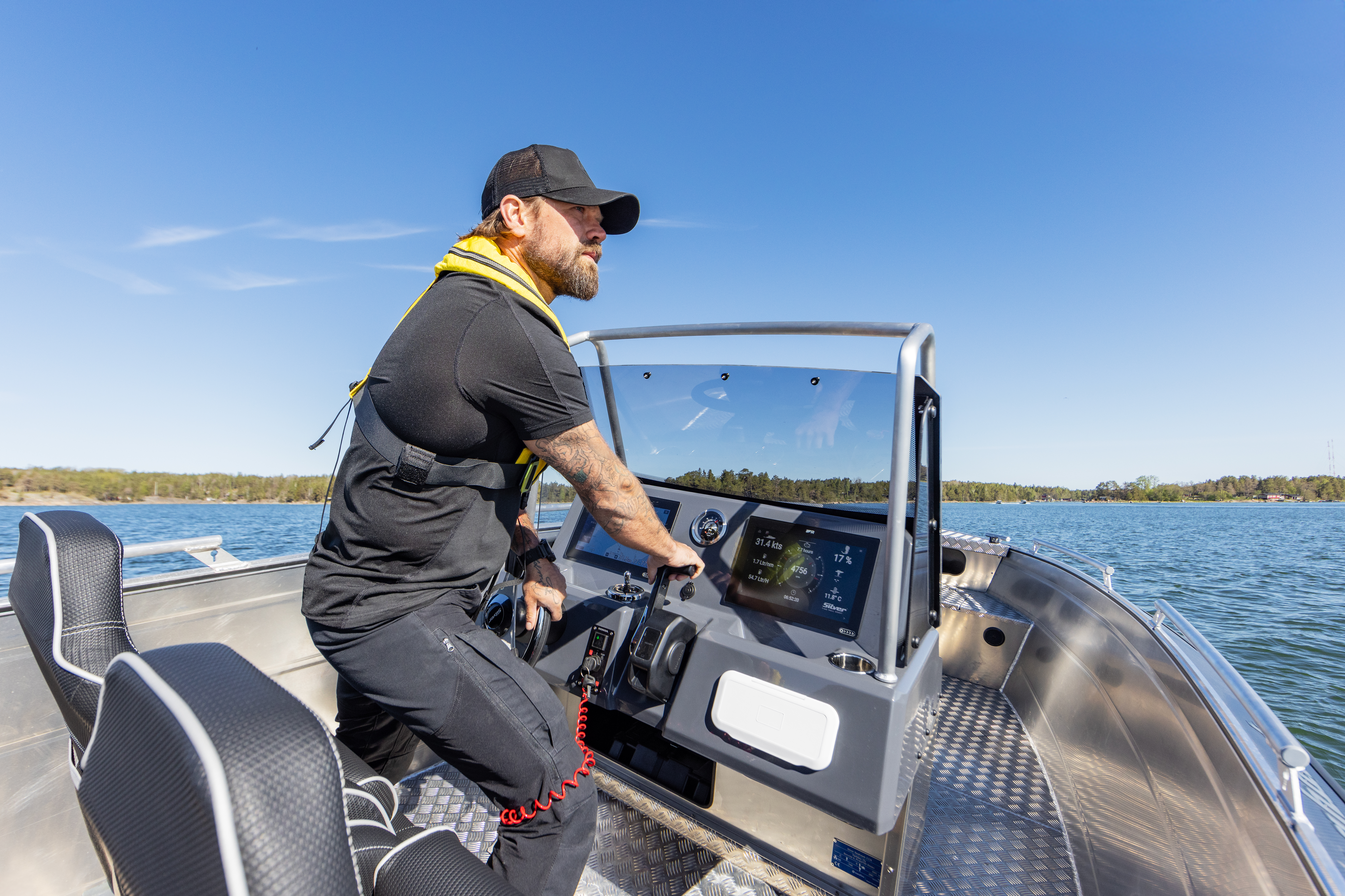 Lippalakkipäinen parrakas mies ajaa seisten täysalumiinista Silver Seahawk CCX -keskipulpettivenettä.